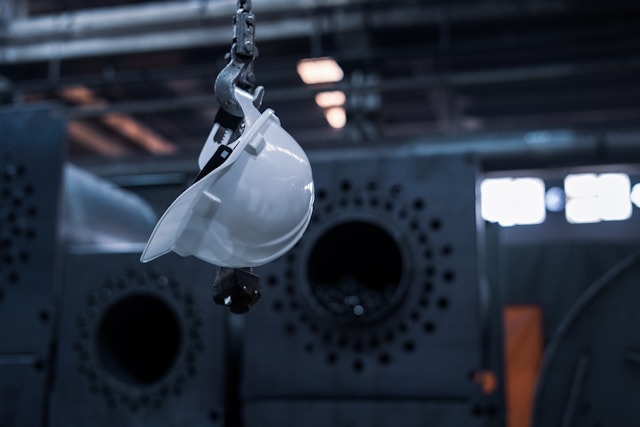 Symbol der Deindustrialisierung: Ein Arbeitsschutzhelm hängt an einem Ladekranhaken