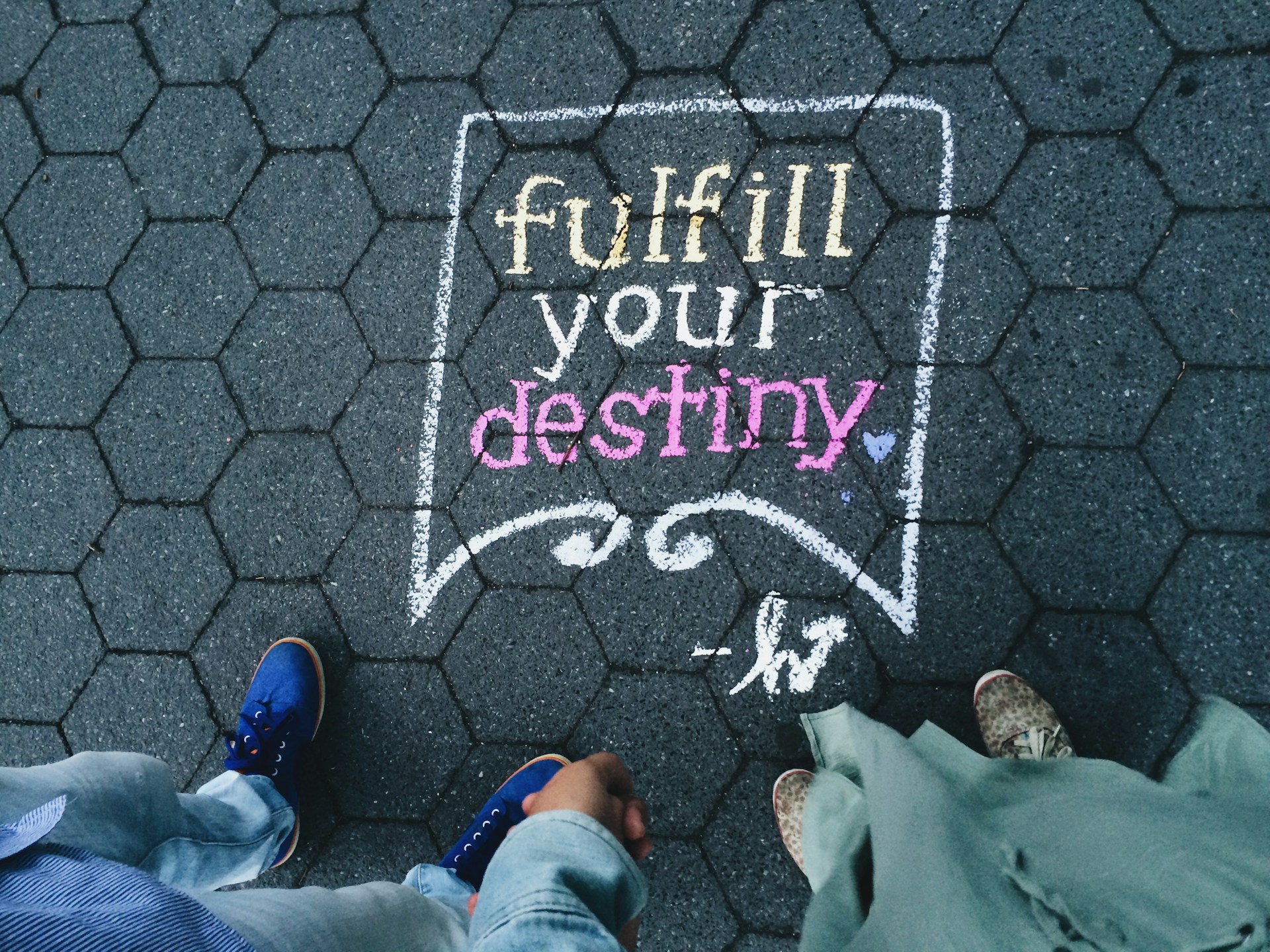 Die Wörter “Fulfill Your Destiny” mit kreide auf den Gehweg geschrieben